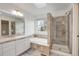 Bright bathroom with a soaking tub, glass shower, and vanity with a large mirror at 6054 W Adriatic Pl, Lakewood, CO 80227