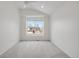 Bright bedroom featuring neutral carpet, ceiling fan, and large window at 6054 W Adriatic Pl, Lakewood, CO 80227