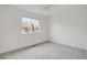 Bright bedroom featuring neutral carpet, ceiling fan, and large window at 6054 W Adriatic Pl, Lakewood, CO 80227