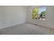 Bright bedroom with neutral carpet and walls, complemented by a large window offering natural light and pleasant views at 6054 W Adriatic Pl, Lakewood, CO 80227