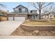 Charming two-story home featuring a brick facade, covered porch, and well-manicured front yard with a two-car garage at 6054 W Adriatic Pl, Lakewood, CO 80227