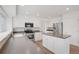 Bright kitchen with stainless steel appliances, white cabinetry, gray countertops, and hardwood flooring at 6054 W Adriatic Pl, Lakewood, CO 80227