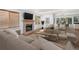 Bright living room featuring a brick fireplace, hardwood floors, and large windows with window coverings at 6054 W Adriatic Pl, Lakewood, CO 80227