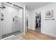 Modern bathroom featuring a spacious shower with glass doors and a glimpse into the walk-in closet at 5944 S Yank Ct, Littleton, CO 80127