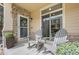 Inviting front porch featuring rocking chairs, stone accents, and a decorative wreath on the front door at 5944 S Yank Ct, Littleton, CO 80127