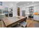 Eat-in kitchen featuring white cabinets, stainless steel appliances and a view into the dining and living areas at 5944 S Yank Ct, Littleton, CO 80127