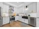 Modern kitchen features white cabinets, stainless steel appliances, stylish backsplash and a farmhouse sink at 5944 S Yank Ct, Littleton, CO 80127