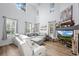Bright living room featuring high ceilings, large windows, hardwood floors, and a cozy fireplace at 5944 S Yank Ct, Littleton, CO 80127