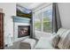 Cozy living room featuring a fireplace with a TV, comfortable seating, and a large window at 5944 S Yank Ct, Littleton, CO 80127