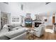 Open-concept living room with a fireplace, tall windows, hardwood floors, and modern decor at 5944 S Yank Ct, Littleton, CO 80127