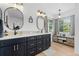 Stylish main bathroom has dual sinks, dark blue cabinets, wood-look floors, and modern fixtures at 5944 S Yank Ct, Littleton, CO 80127