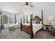 Bright main bedroom with a four-poster bed, ceiling fan, and chaise lounge under the windows at 5944 S Yank Ct, Littleton, CO 80127