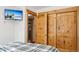 Cozy bedroom showcases knotty pine closet doors, a television, and light-filled doorway at 142 High Point Dr, Breckenridge, CO 80424