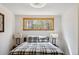 Bright bedroom featuring a plaid comforter, stylish lamps, and large window with woodland views at 142 High Point Dr, Breckenridge, CO 80424