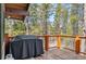 Outdoor deck with a grill and views of the surrounding evergreen trees at 142 High Point Dr, Breckenridge, CO 80424
