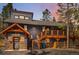 Charming exterior showcasing stone accents, a wooden deck, and rustic design, nestled among tall pine trees at 142 High Point Dr, Breckenridge, CO 80424