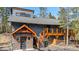Inviting exterior features a wooden deck, stone accents, and a well-maintained yard with tall trees at 142 High Point Dr, Breckenridge, CO 80424