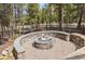 Stone fire pit surrounded by tall trees on a sunny day at 142 High Point Dr, Breckenridge, CO 80424