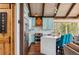 Modern kitchen featuring wooden floors, stainless steel appliances, turquoise cabinets, and a white countertop island with seating at 142 High Point Dr, Breckenridge, CO 80424