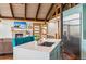 View of modern kitchen with stainless steel refrigerator, white countertops and island with seating area near a fireplace at 142 High Point Dr, Breckenridge, CO 80424