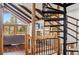 View from the spiral staircase to living room with a fireplace, wooden beams and window views at 142 High Point Dr, Breckenridge, CO 80424