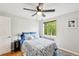 Bright bedroom featuring a large window, hardwood floors, ceiling fan, and a comfortable bed with stylish bedding at 1182 Clermont St # A202, Denver, CO 80220