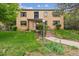 Attractive brick building featuring a tidy lawn and pathway leading to the entrance, framed by mature trees at 1182 Clermont St # A202, Denver, CO 80220
