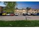 Apartment Building featuring a well-maintained brick facade, covered entryway, and ample parking on a sunny day at 1182 Clermont St # A202, Denver, CO 80220