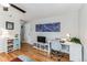 Open concept living space with light hardwood floors, ceiling fan, a desk area, and front door at 1182 Clermont St # A202, Denver, CO 80220