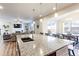 Open-concept kitchen with an island, granite countertops, and views of the living and dining areas at 2065 E 150Th Pl, Thornton, CO 80602