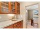 Butlers pantry with wood cabinets, light countertops and view into the dining room with tray ceiling at 13744 W 86Th Dr, Arvada, CO 80005