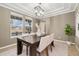 Bright dining room featuring a modern chandelier, large windows, and neutral decor at 13744 W 86Th Dr, Arvada, CO 80005