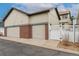 Residential exterior showcasing attached garages with brick accents, offering convenient parking and curb appeal at 13744 W 86Th Dr, Arvada, CO 80005