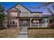 Inviting two-story home featuring a covered porch, brick accents, and well-maintained landscaping at 13744 W 86Th Dr, Arvada, CO 80005