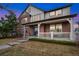Charming two-story brick home with a welcoming front porch and manicured lawn at 13744 W 86Th Dr, Arvada, CO 80005
