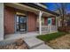 Inviting front porch with brick columns and decorative railings leading to the entry at 13744 W 86Th Dr, Arvada, CO 80005