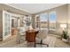 Stylish home office bathed in natural light, featuring French doors, neutral colors and a cozy workspace at 13744 W 86Th Dr, Arvada, CO 80005