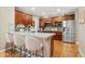 Spacious kitchen featuring an island with bar seating, stainless steel refrigerator, and ample cabinetry at 13744 W 86Th Dr, Arvada, CO 80005