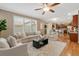 Inviting living room featuring a comfortable sofa, modern ceiling fan, and large windows at 13744 W 86Th Dr, Arvada, CO 80005