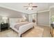 Bedroom featuring a ceiling fan, neutral color palette, and en suite bathroom with a barn door at 13744 W 86Th Dr, Arvada, CO 80005