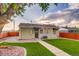 This backyard features a green lawn, manicured landscaping, and privacy fence at 488 S Leyden St, Denver, CO 80224