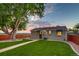 Backyard featuring green lawn, mature tree, stone walkway, and wood perimeter fence at dusk at 488 S Leyden St, Denver, CO 80224