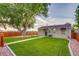 The backyard is landscaped with lush green grass, a privacy fence and a mature tree at 488 S Leyden St, Denver, CO 80224