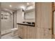 Modern bathroom featuring a glass shower and woodgrain vanity with black countertop at 488 S Leyden St, Denver, CO 80224