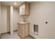 Laundry area with wood cabinet, white countertop, chrome faucet, and tiled flooring at 488 S Leyden St, Denver, CO 80224