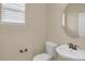 Clean bathroom with a pedestal sink, toilet and oval mirror at 21719 E Tallkid Ave, Parker, CO 80138