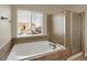 Bathroom with soaking tub, shower, and window with blinds at 21719 E Tallkid Ave, Parker, CO 80138