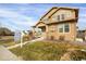 Tan two-story house with a covered porch and landscaped yard at 21719 E Tallkid Ave, Parker, CO 80138