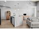 Open concept living area with kitchen island, modern lighting and a light color palette at 891 14Th St # 1211, Denver, CO 80202