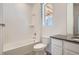 Clean bathroom featuring a shower-tub combo, a single sink, and white tiled walls at 2128 S Haleyville Way, Aurora, CO 80018